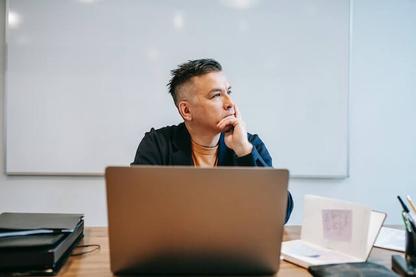 Man thinking about something in fromnt of a computer